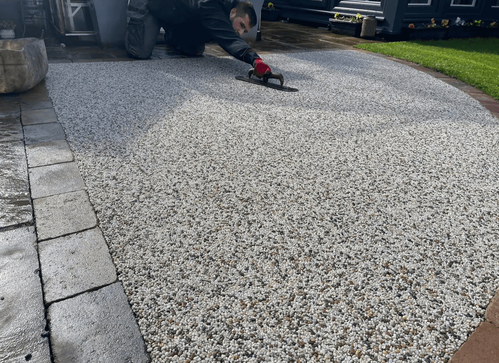 Grey resin-bound driveway meeting a contrasting block-paved border